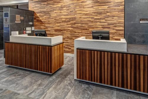 a lobby with two reception desks and a brick wall at Courtyard by Marriott Dulles Airport Herndon in Herndon