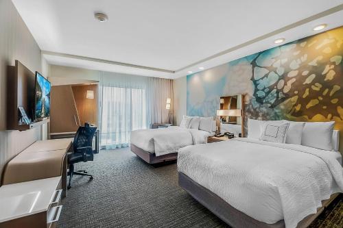 ロングビューにあるCourtyard by Marriott Longview Northのベッド2台とデスクが備わるホテルルームです。