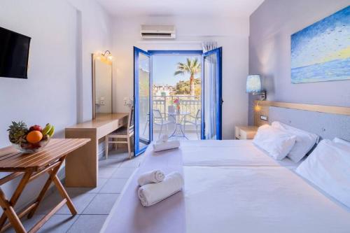 een hotelkamer met een bed, een tafel en een bureau bij Sergiani Garden Hotel Apartments in Stalida