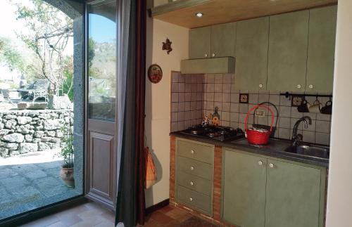 cocina con fregadero y fogones en Villa Alessio - Case Vacanza con Piscina sull'Etna, en Puntalazzo