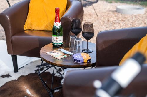 Una botella de vino y dos copas en una mesa. en Bubble Tent Gutach- Schlafen unterm Sternenhimmel, en Gutach im Breisgau