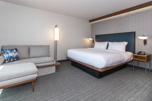 a hotel room with a bed and a couch at Courtyard by Marriott Rapid City in Rapid City