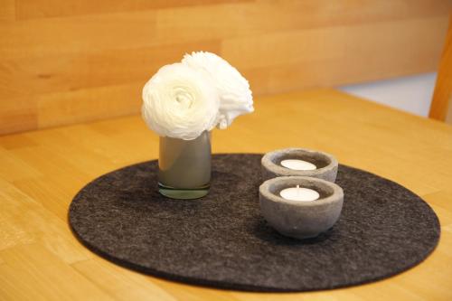 a vase with a white flower and a candle on a table at Ferienhaus Buhne 31 in Prerow