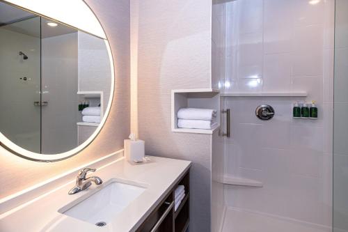 a bathroom with a sink and a mirror at Courtyard by Marriott Rapid City in Rapid City