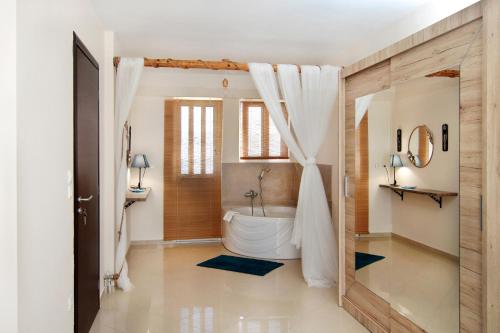 a bathroom with a white tub and a shower at Marathon Beachside Homes next to Schinias Beach in Schinias