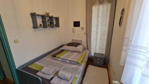a small bedroom with two beds in a room at RI-JÓ apartman in Mohács