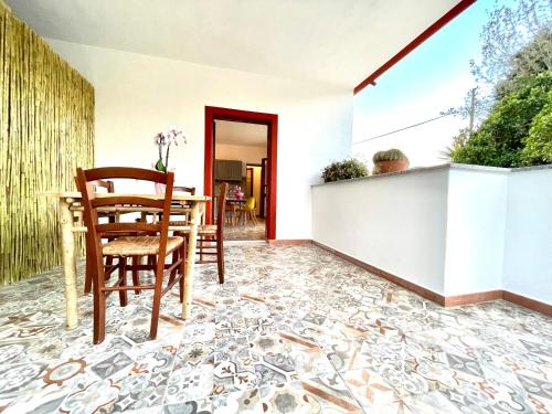 a dining room with a table and chairs on a mosaic floor at Le Corti Sarde Countryside in Bari Sardo