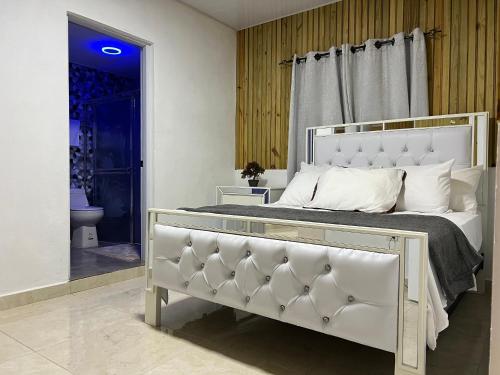 a bedroom with a large bed with a white headboard at Alaia Casa de campo By Hospedify Para 10 personas en la naturaleza con BBQ cerca de rió cristalino in Jarabacoa