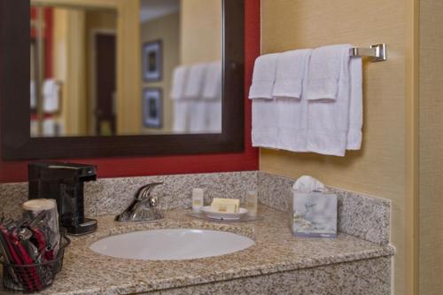 a bathroom with a sink and a mirror and towels at Courtyard by Marriott Richmond Northwest in Henrico