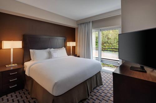 a bedroom with a bed and a flat screen tv at Residence Inn by Marriott Seattle South/Renton in Renton