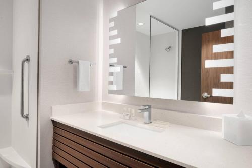 a bathroom with a sink and a mirror at Courtyard by Marriott Houston I-10 West/Memorial in Houston