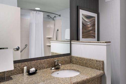 uma casa de banho com um lavatório e um chuveiro em Courtyard by Marriott Portland Airport em South Portland