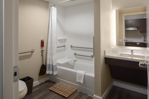 a bathroom with a sink and a toilet and a mirror at TownePlace Suites by Marriott Tampa South in Tampa
