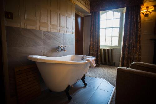 a bath tub in a bathroom with a window at Royal Oak Hotel in Betws-y-coed