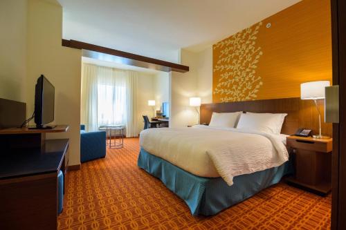 a hotel room with a bed and a flat screen tv at Fairfield Inn & Suites by Marriott Delray Beach I-95 in Delray Beach