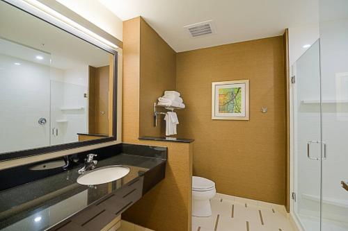a bathroom with a sink and a toilet and a mirror at Fairfield Inn & Suites by Marriott Delray Beach I-95 in Delray Beach