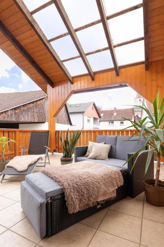 a patio with a bed and a couch on a patio at Rhön & Relax Schwarze Berge - Garten in Wildflecken