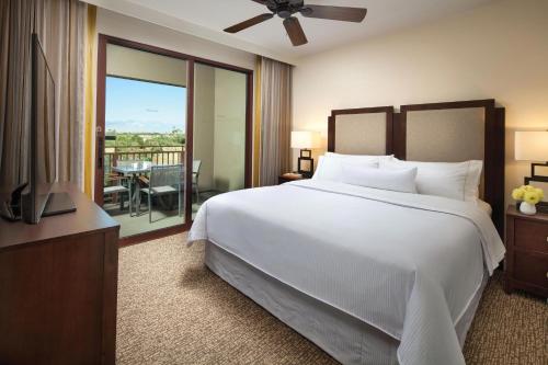 a bedroom with a large white bed and a balcony at The Westin Desert Willow Villas, Palm Desert in Palm Desert