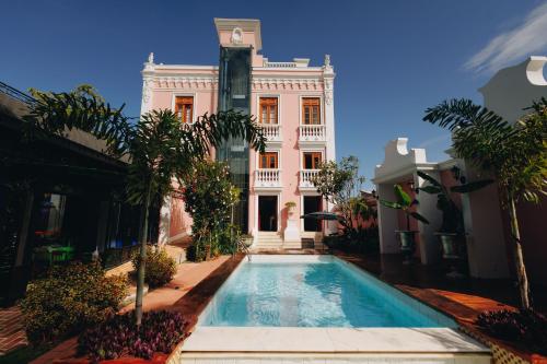 a building with a swimming pool in front of a building at Hotel Boutique Quinta das Videiras in Florianópolis