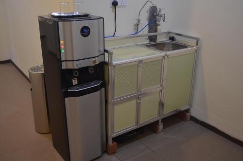 eine Küche mit einer Spüle und einem Kühlschrank in der Unterkunft Welcome Inn GM in Gua Musang
