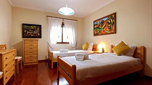 um quarto com duas camas e uma cómoda em Ocean and River Apartment em Torreira