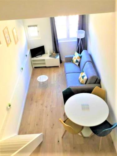 un salon avec un canapé bleu et une table dans l'établissement L'Appart de l'Hôtel de Ville, à Arles