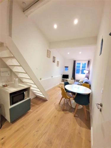 un salon avec une table et un escalier dans l'établissement L'Appart de l'Hôtel de Ville, à Arles