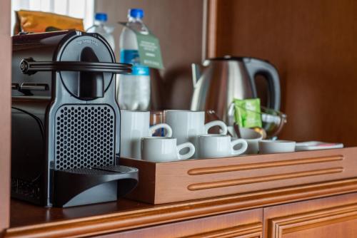 a coffee maker and cups on a kitchen counter at Divisa Experience Resort in São Francisco de Paula