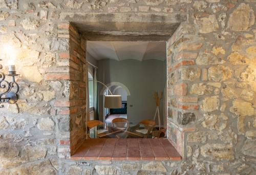 a stone wall with a doorway into a room with a table at Relais La Martina in Pietraviva