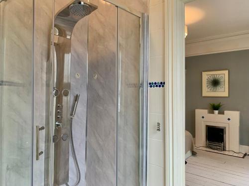 La salle de bains est pourvue d'une douche avec une porte en verre. dans l'établissement Somerford Place - 6 Beds - Sleeps 12 - Parks 2-3 cars/vans, à Willenhall