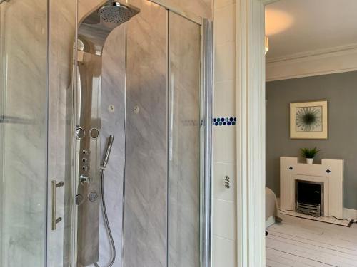 a shower with a glass door in a bathroom at Spacious 6BR Victorian Home in 14 Somerford Near Wolverhampton Centre with Free Parking in Willenhall