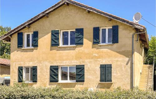 a yellow house with blue shutters on it at Cozy Apartment In Mauléon D'armagnac in Mauléon-dʼArmagnac