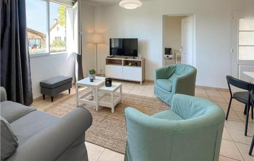 a living room with a couch and chairs and a tv at Cozy Apartment In Mauléon D'armagnac in Mauléon-dʼArmagnac