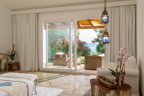 a living room with a view of the ocean at Arbatax Park Resort - Cottage in Àrbatax