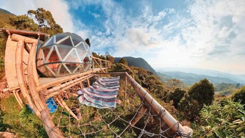 a roller coaster in the mountains with people on it at Glamping Entre Nubes in Zipacón