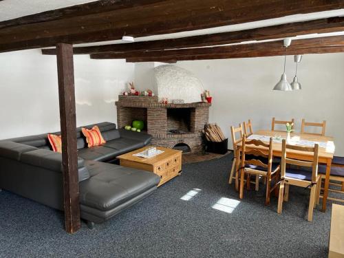 sala de estar con sofá, mesa y chimenea en Romantisches Schwarzwaldhaus, en Äule