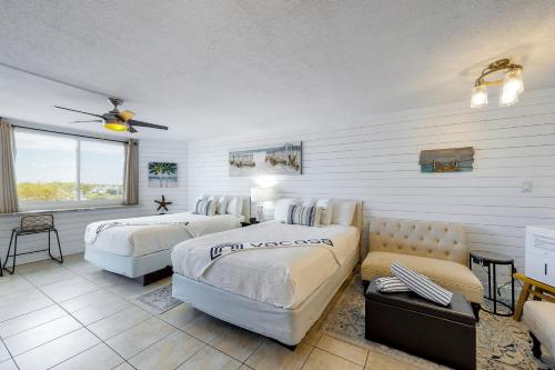 a hotel room with two beds and a couch at Top of the Gulf 702 Teal Waters in Panama City Beach