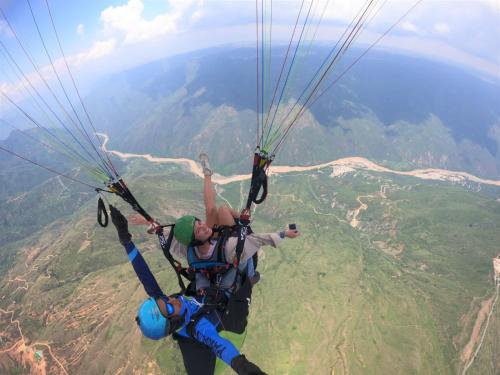 a man hanging from a parachute in the sky at GREEN DOOR HOSTEL BOUTIQUE in San Gil