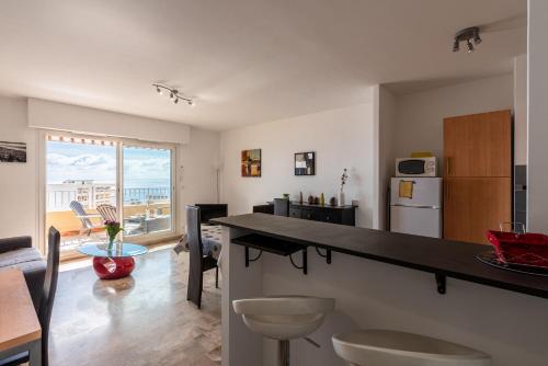- une cuisine et un salon avec un comptoir et une table dans l'établissement Ajaccio, Sanguinaires, Hélios, vue mer magnifique, T2 4pers, à Ajaccio