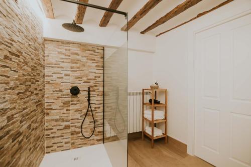 a bathroom with a shower and a brick wall at Puracepa - Urban Suites in Haro