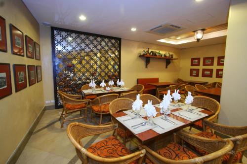 a dining room with tables and chairs and a window at Crown Regency Prince Resort in Boracay