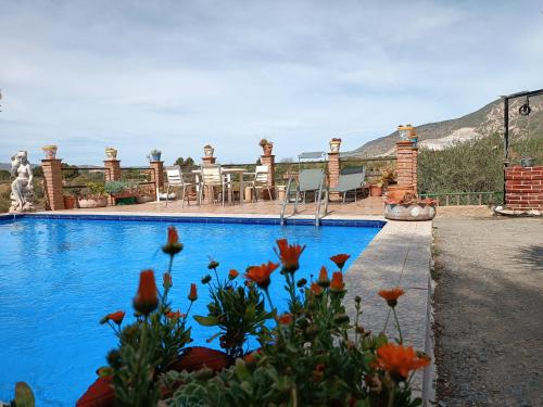 una piscina con flores frente a una casa en El Río, en Dúrcal