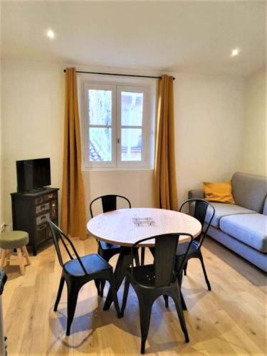 un salon avec une table, des chaises et un canapé dans l'établissement Appart lumineux de l'Hôtel de Ville, à Arles