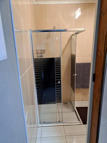 a shower with a glass door in a bathroom at Horizon View Chalets in Graskop