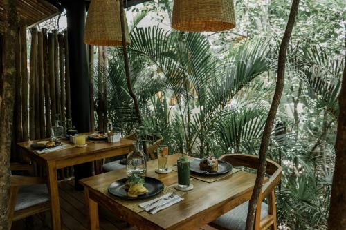 una mesa de madera con platos de comida. en Copal Tulum Hotel, en Tulum