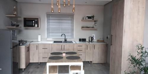 a kitchen with a table in the middle of it at Bird Nest Lodge in Durban