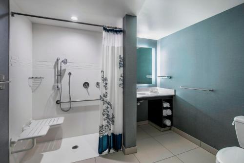a bathroom with a shower and a toilet and a sink at Residence Inn by Marriott Regina in Regina