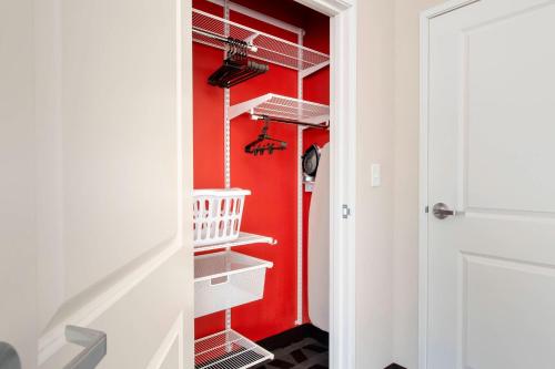 a red closet with white shelves and a red wall at TownePlace Suites by Marriott College Park in College Park