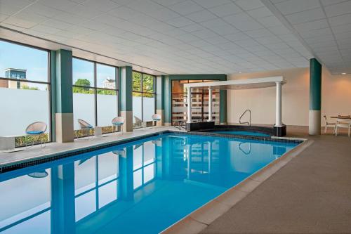 a large swimming pool with blue water and windows at Delta Hotels by Marriott Richmond Downtown in Richmond