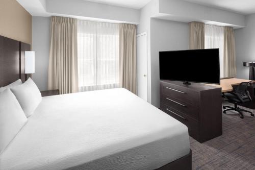 a hotel room with a bed and a flat screen tv at Residence Inn Tampa Oldsmar in Oldsmar